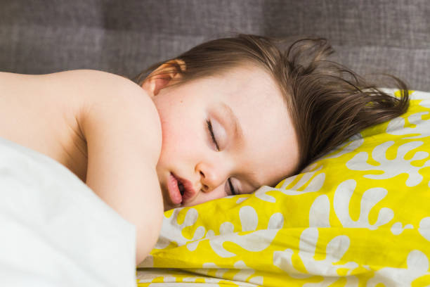 la petite fille d'enfant dort, sommeil profond d'un beau bébé avec des yeux fermés, plan rapproché - pillow wake up yawning sleeping photos et images de collection