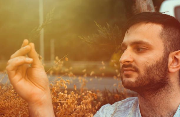 istock Portrait of young handsome man is holding a pine tree leaf 1165280765