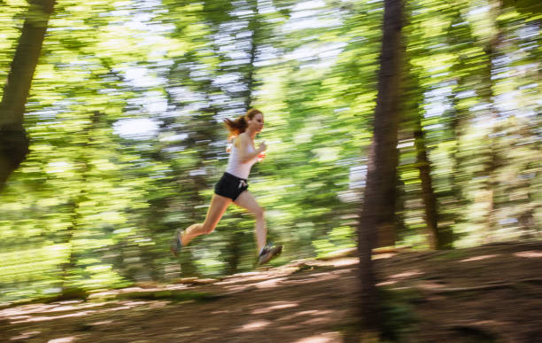 istock Young Woman Running Through The Woods, Blurred Motion 1165283151
