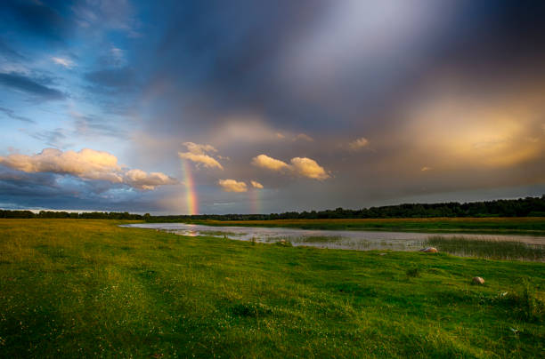 istock Beautiful summer landscape with double rainbow in dramatic sky over the river 1165285102