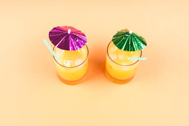 Cup  with an umbrella and tube on yellow background