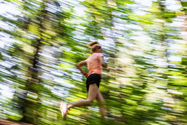 istock Young Woman Running Through The Woods, Blurred Motion 1165287289