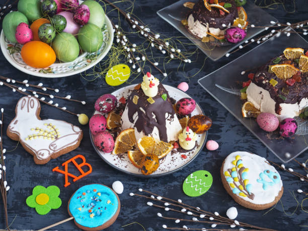 istock Generous Easter treat, cottage cheese Easter with chocolate and fruit, painted eggs and gingerbread on a dark background 1165288506