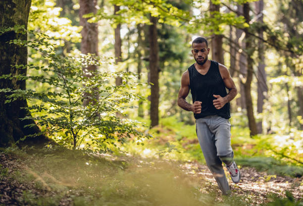 istock Young Man Running Through The Woods 1165289074