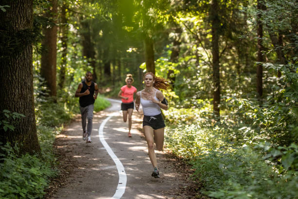 istock Small Group of People Running Through The Woods 1165289724