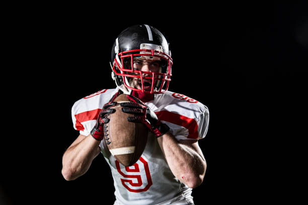 verticale de quart-arrière sur le fond noir - football helmet playing field american football sport photos et images de collection