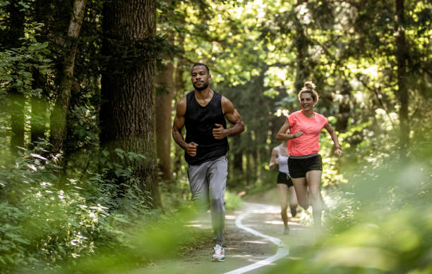 istock Small Group of People Running Through The Woods 1165290364