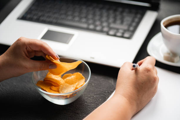 istock Unhealthy snacking, eating junk food at workplace 1165291465