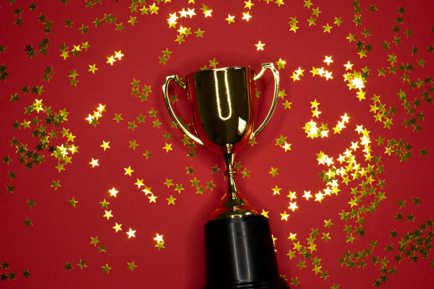 istock gold winning cup on red background , success concept 1165291576