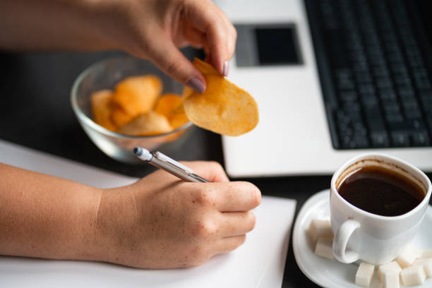 istock Unhealthy snacking, eating junk food at workplace 1165291580