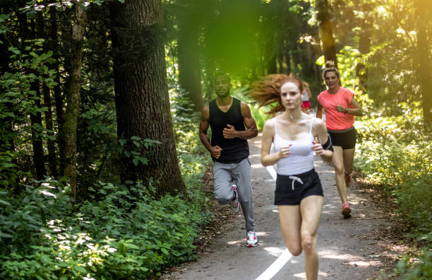 istock Small Group of People Running Through The Woods 1165291775