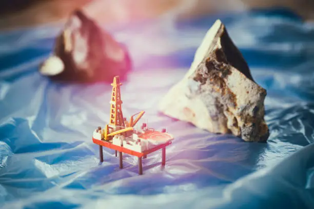 Tabletop shot with homemade model of a drilling platform and two flints
