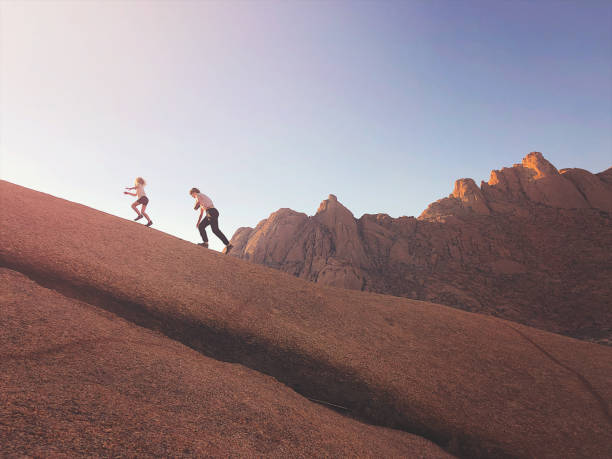 istock Girls walking up steep granite rock 1165300757