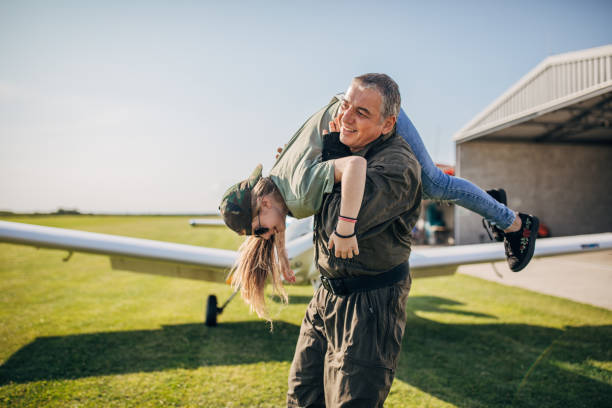 istock Father pilot and daughter playing together by the airplane 1165304461