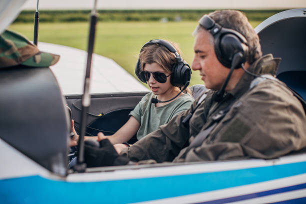 istock Young girl and pilot sitting in cockpit 1165305376