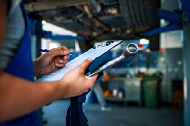 specialista automobilistico che regola un motore - car examining mechanic auto mechanic foto e immagini stock