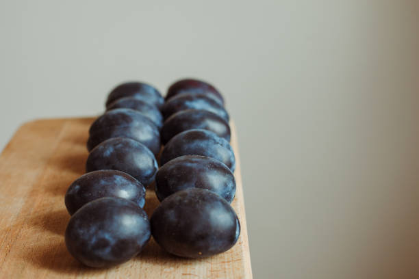 istock plums on a wooden board 1165318508