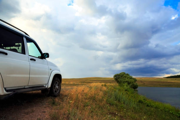 Saratov, Russia - 06/28/2019: Traveling tourism by car SUV. UAZ Patriot in the evening on the nature on the road against the backdrop of a field of forest and a dramatic sky in a thunderstorm Saratov, Russia - 06/28/2019: Traveling tourism by car SUV. UAZ Patriot in the evening on the nature on the road against the backdrop of a field of forest and a dramatic sky in a thunderstorm uaz 4x4 land vehicle woods stock pictures, royalty-free photos & images