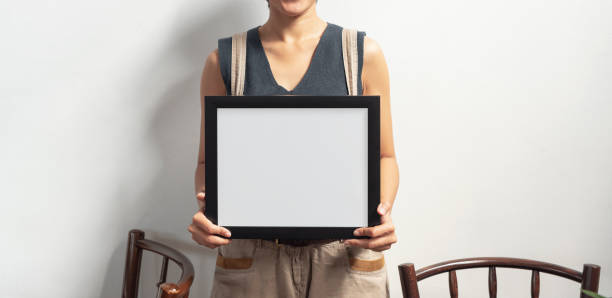 istock Hand Holding Blank Black Photo Frame for Design Mockup Template. 1165318571