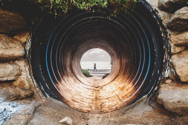istock Old large pipe tunnel by the coast 1165318832