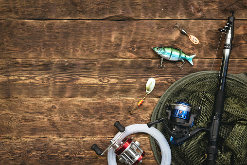 Fishing flat lay background with a copy space. Fishing gear on a wooden table.