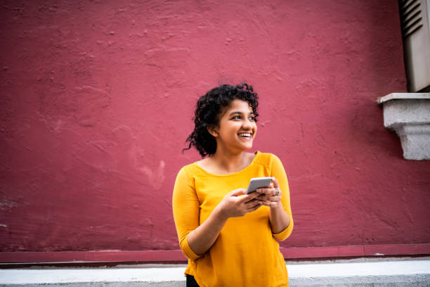 istock Smiling Indian woman using mobile phone 1165322592