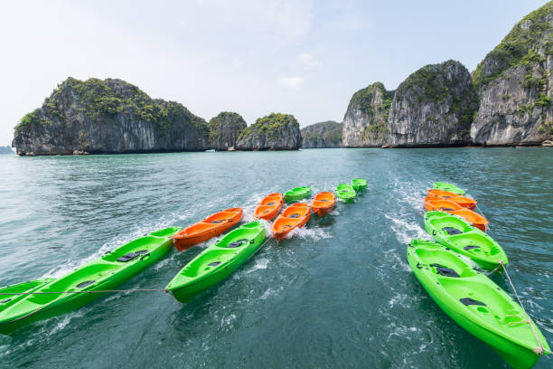 zielone i pomarańczowe plastikowe kajaki w zatoce halong, wietnam - halong bay vietnam bay cruise zdjęcia i obrazy z banku zdjęć