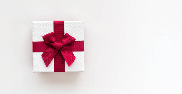 istock White gift box with red ribbon isolated on white background. Top view. 1165324603