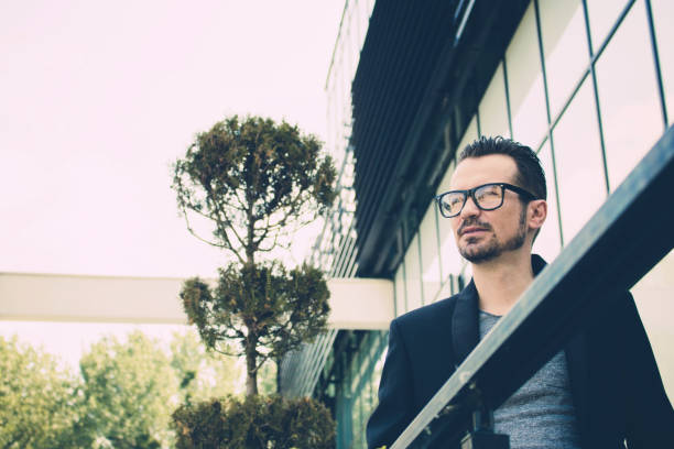 istock Pensive businessman in front of a building. 1165325988