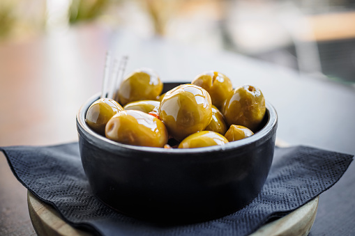 Green spicy olives spanish tapa on a black bowl