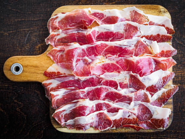 Iberico ham cut on a wooden board, spanish typical tapa stock photo