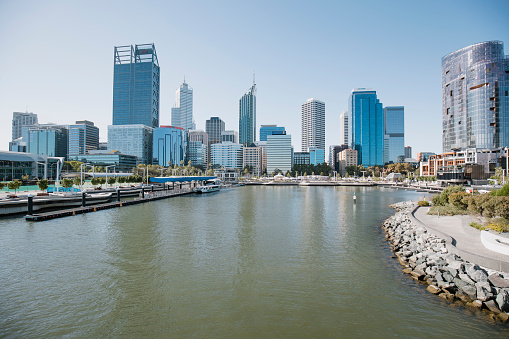 View of the skyline of Perth, Australia from across the Swan River. There is a ferry port on the waterside.