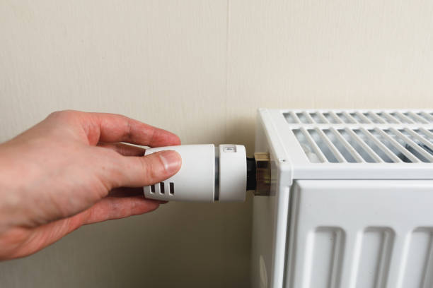istock hand controls thermostatic knob of heating radiator 1165328574