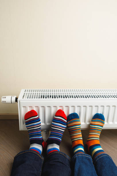 istock legs with colorful socks in front of heating radiator 1165329288