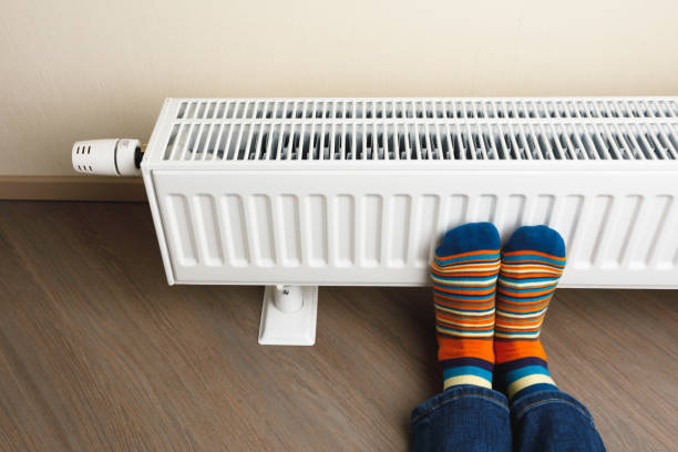 istock legs with colorful socks in front of heating radiator 1165329316