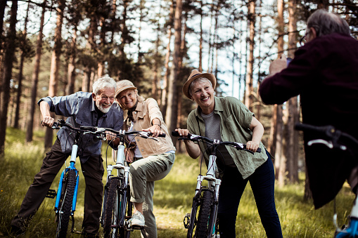 Close up of a group of seniors taking a picture together while out biking in the forest
