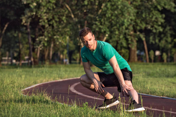 istock Young man doing warm-up exercise in the park 1165330949