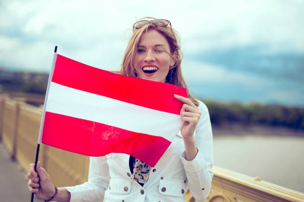 istock Happy young excited woman holding Austrian flag on bridge 1165334093