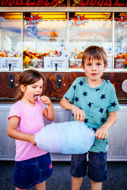 istock Children eating candy floss at amusement park 1165334125