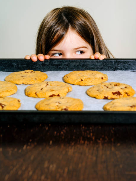 istock Young girl looking at freshly baked cookies 1165334183