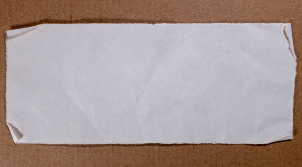 istock Blank white paper on brown cardboard background 1165335339