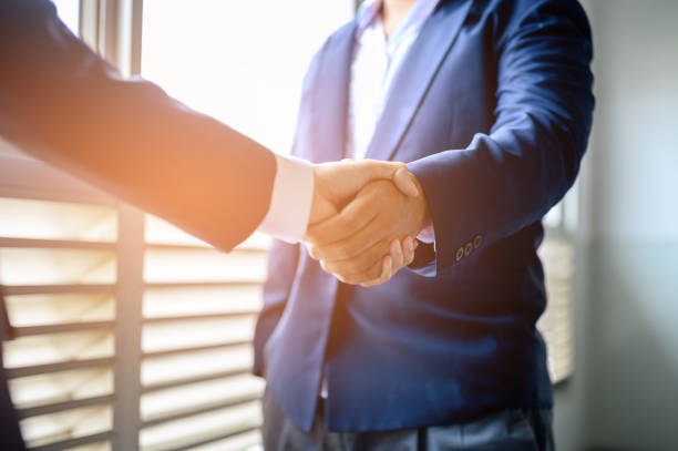 istock Two businessmen join hands for business cooperation. 1165339065