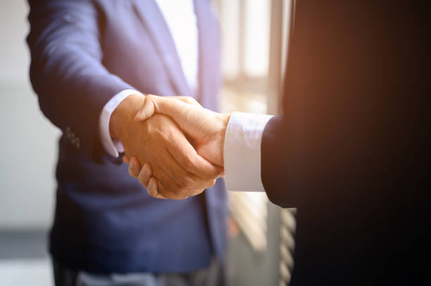 istock Two businessmen join hands for business cooperation. 1165339155