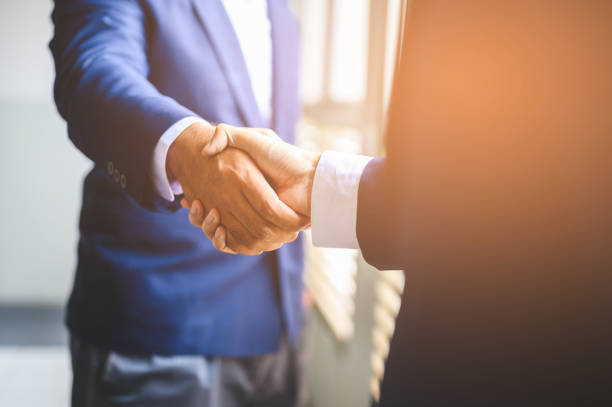 istock Two businessmen join hands for business cooperation. 1165339156