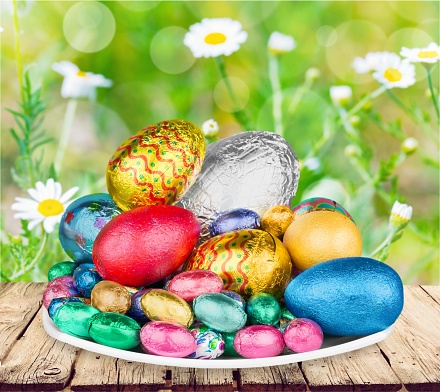 Group of colorful candy Easter eggs wrapped in foil with bow