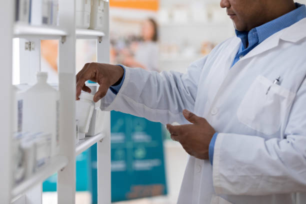 istock Pharmacist takes medication off of shelf 1165344671
