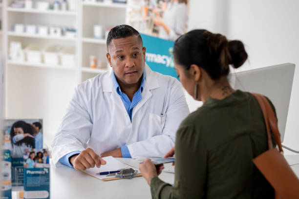 istock Pharmacy customer talks with pharmacist about flu vaccine 1165344721