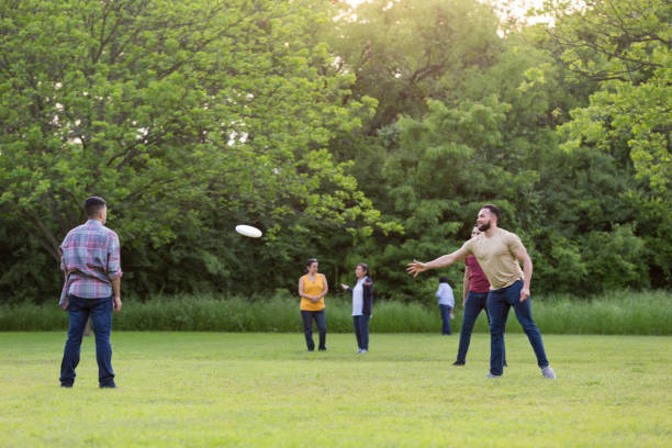 istock While women chat, brothers toss frisbee 1165344954