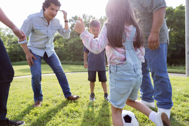 istock Multi-generational group stands in circle to kick soccer ball 1165344991