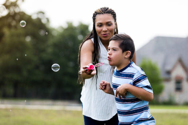 maman et fils jouant avec la baguette magique de bulle - bubble wand child outdoors bubble photos et images de collection